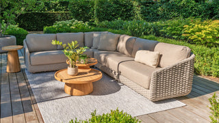 Das Zeo Living 4Seasons Lounge-Set Casanova Rope Latte umfasst ein Korbsofa, runde Holztische und Topfpflanzen auf einer Holzterrasse, komplett mit wetterfesten Kissen für dauerhaften Komfort bei jedem Wetter.