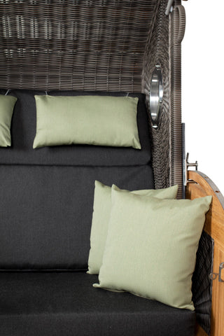 Der DeVries Strandkorb Pure Sailor XL in Steingrau mit schwarzen Polstern und hellgrünen Kissen ergänzt sein elegantes Design. Eine Holzarmlehne auf der rechten Seite unterstreicht seinen stilvollen Look.