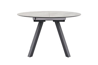 Der Kettler Ausziehtisch von Kettler ist ein runder grauer Tisch mit schwarzen Beinen, einer geteilten HPL-Tischplatte und pulverbeschichtetem Aluminium-Gestell.