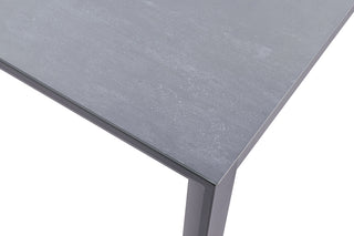 Nahaufnahme der eleganten, modernen Ecke des Lesli Living Gartentischs Mojito 220 x 100 cm mit einer strukturierten grauen Glaskeramikoberfläche und sauberen Kanten, unterstützt durch pulverbeschichtetes Aluminium.