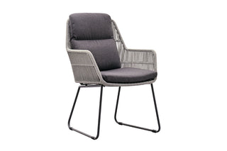 Der Zeo Living Set Dining Stuhl Florenz in Grau verfügt über graue Olefin-Kissen, eine schlichte Rückenlehne aus Rope-Geflecht und moderne Metallbeine, aus der Perspektive betrachtet.